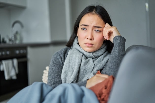 young women sad sitting on couch.